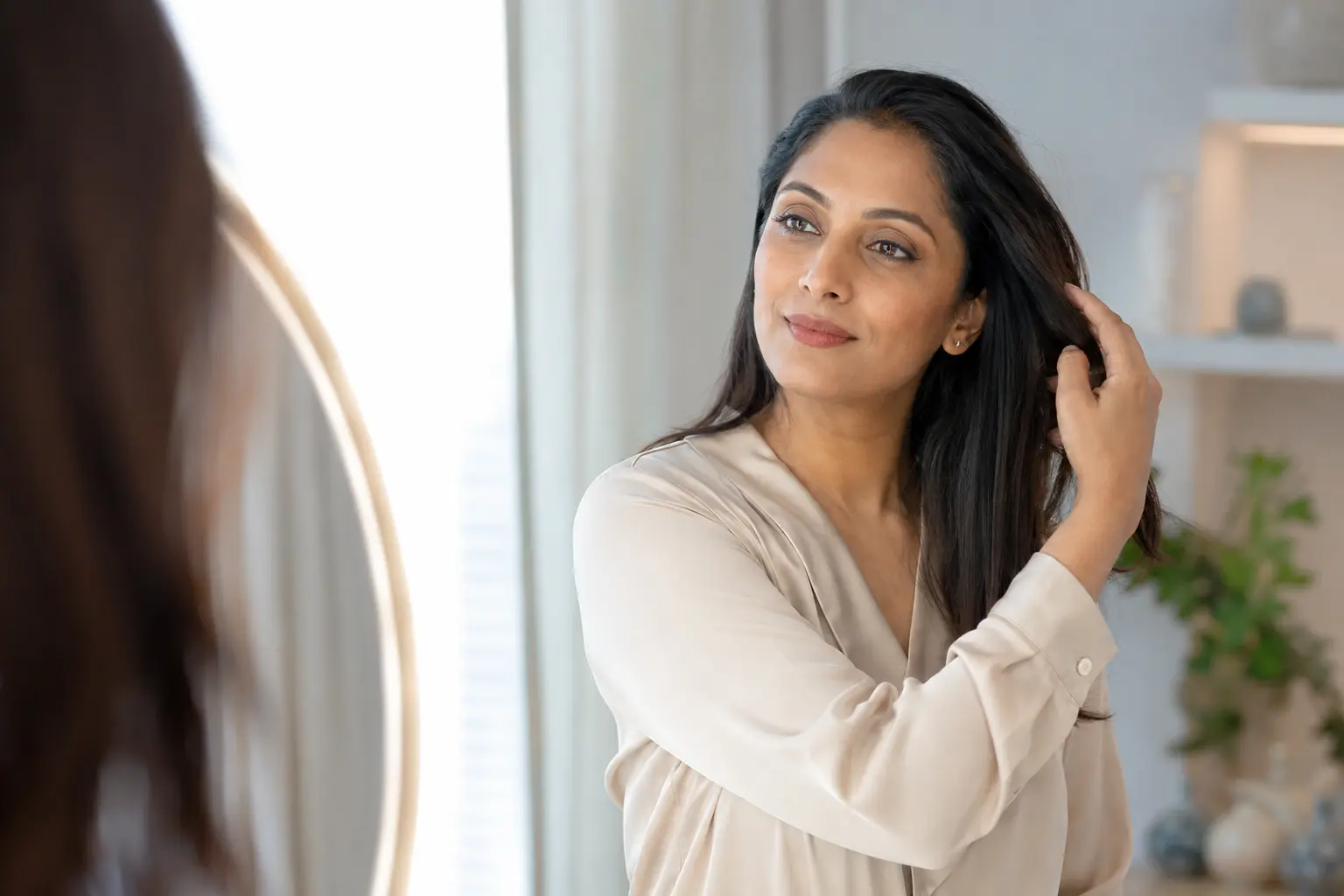 An adult woman practicing a calm hair-care routine at home